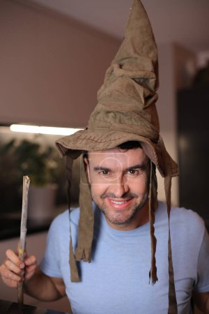Man wearing a wizard hat and holding a magic wand
