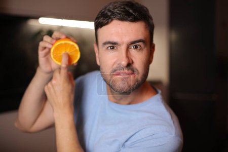 Photo for Man showing the interior of orange fruit - Royalty Free Image