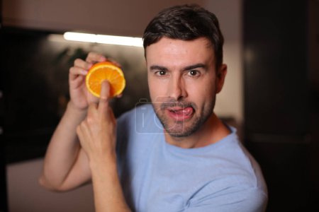 Photo for Man showing the interior of orange fruit - Royalty Free Image