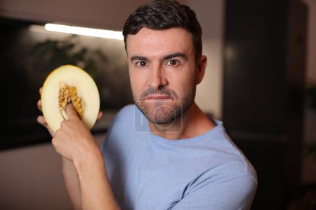 Foto de Hombre mostrando el interior de una fruta en el fondo, de cerca - Imagen libre de derechos