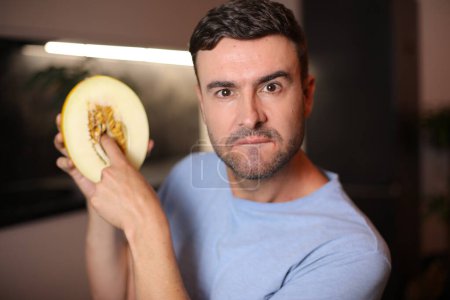 Foto de Hombre mostrando el interior de una fruta en el fondo, de cerca - Imagen libre de derechos