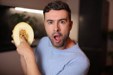 Photo for Man showing the interior of a fruit on background, close up - Royalty Free Image