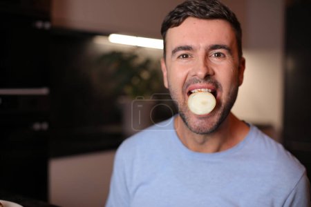 Téléchargez les photos : Homme avec la moitié d'un oignon dans sa bouche ouverte - en image libre de droit