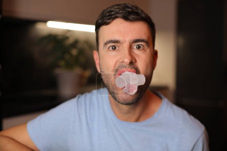 Téléchargez les photos : Un homme tenant un glaçon entre ses lèvres - en image libre de droit