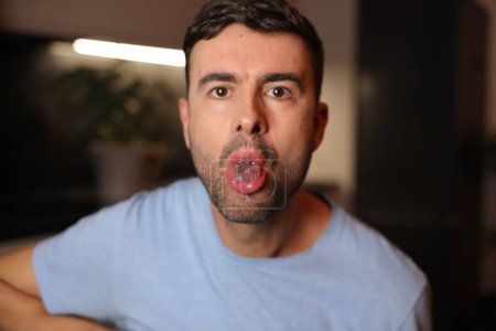 Man holding an ice cube between his lips