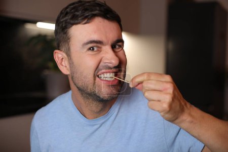 Foto de Hombre usando un palillo de dientes después del almuerzo en el fondo, de cerca - Imagen libre de derechos