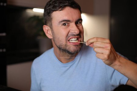 Téléchargez les photos : Homme utilisant un cure-dent après le déjeuner sur fond, gros plan - en image libre de droit