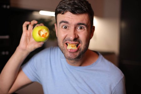Foto de Hombre con encías ensangrentadas después de morder una manzana - Imagen libre de derechos