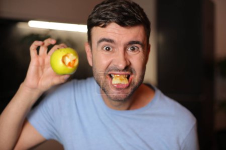 Foto de Hombre con encías ensangrentadas después de morder una manzana - Imagen libre de derechos