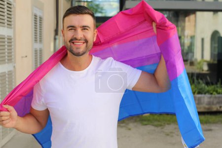 Fier homme agitant le drapeau bisexuel