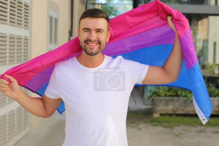 Fier homme agitant le drapeau bisexuel