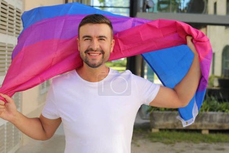 Foto de Hombre orgulloso ondeando la bandera bisexual - Imagen libre de derechos
