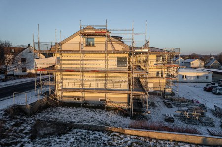 Foto de Reconstrucción de edificio residencial en pueblo europeo, andamio de trabajo, vista aérea - Imagen libre de derechos
