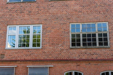 Foto de Grandes ventanas viejas y nuevas, comparación. Estilo vintage, casa antigua de ladrillos. - Imagen libre de derechos