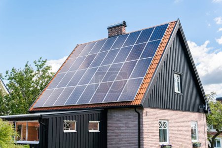 Foto de Solar battery panel on a roof of a private house in Europe. Energy-saving technology. Sunny summer day. - Imagen libre de derechos