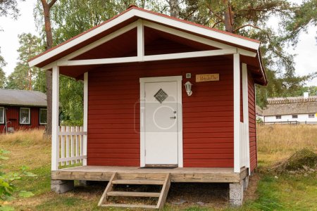 Foto de Pequeñas casitas de madera roja en estilo escandinavo sueco cerca de un campo de golf. Vintage, acogedora vivienda. Lugar ideal para introvertidos. - Imagen libre de derechos