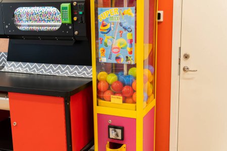 Photo for Sweden, Knislinge  September 16, 2022: Old vintage gaming machine in a shop. Claw crane. Candies and bubble gums machine. Big candy dispenser, gumball bank, gumball dispenser. Entertainment for kids. - Royalty Free Image