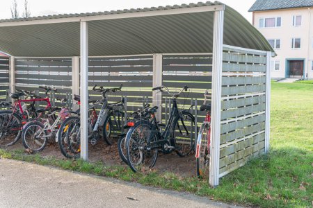 Photo for Sweden, Hanaskog  November 19, 2022: Covered parking, garage for bicycles, strollers, baby carriages outdoors near residential building. Street parking, cycling hub. Cycle parking. - Royalty Free Image