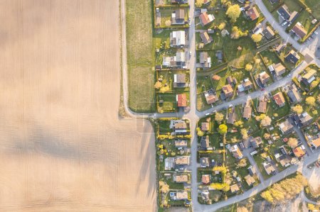 Aerial view of European village in Sweden. Big field and many private houses, residential building. People and nature. Little town. Farming, agriculture in Sweden.