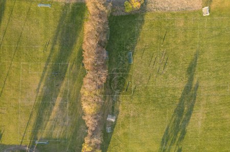 Foto de Vista aérea de un campo de fútbol, campo. Gente jugando fútbol al atardecer, grandes sombras. - Imagen libre de derechos