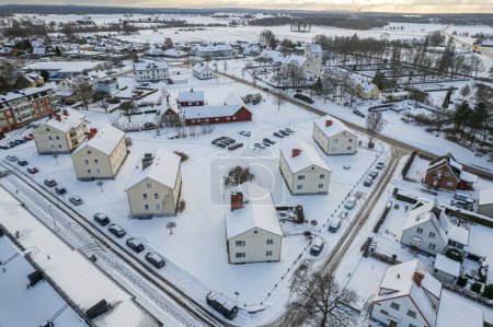 Photo for Aerial view of residential area in Sweden with low-rise and private buildings during winter. Snowy weather, snowfall in a little European village, town, city. - Royalty Free Image