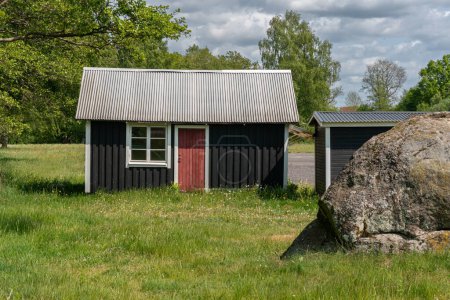 Foto de Una elegante casa de campo de verano vintage, casa de vacaciones de madera negra. Casa típica de fin de semana en Suecia. - Imagen libre de derechos