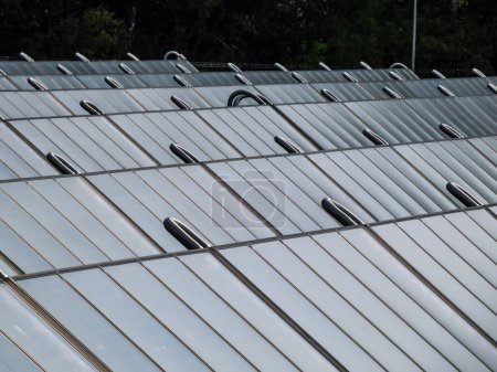 Foto de Paneles solares fotovoltaicos del campo solar que proporcionan energía verde alternativa utilizada para la calefacción. Colectores solares térmicos que generan electricidad, uso de recursos energéticos renovables - Imagen libre de derechos