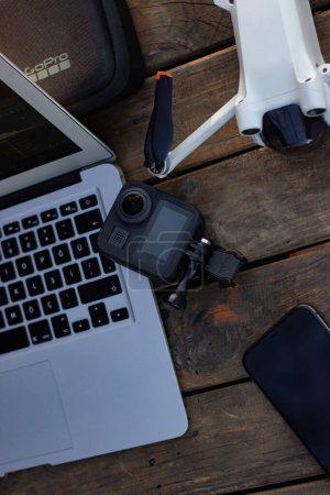 Foto de Mesa de trabajo moderna con ordenador portátil, móvil, taza de café, suministros, cámara. herramientas de oficina, vista superior - Imagen libre de derechos