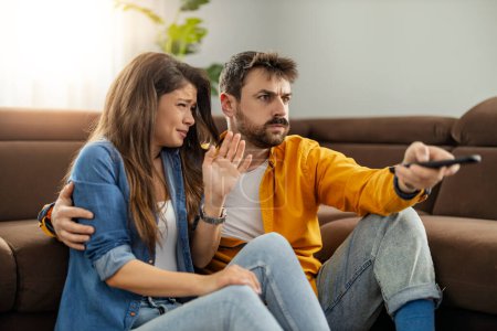 Téléchargez les photos : Jeune couple déçu en regardant match de sport à la télévision à la maison. - en image libre de droit