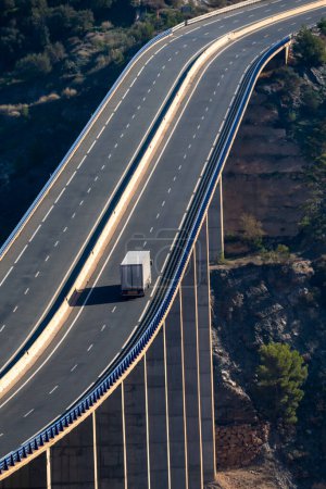 Téléchargez les photos : Camion avec semi-remorque pour la conduite de la cargaison générale sur un viaduc avec beaucoup de hauteur sur un ravin. - en image libre de droit