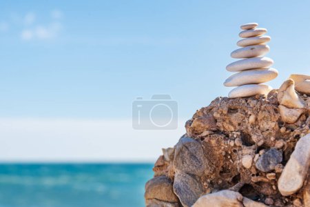 Téléchargez les photos : Pyramide de pierres blanches face à la mer, Apachetas, concept de yoga et équilibre personnel, offrant à la divinité dans certaines villes, stabilité dans la philosophie zen. - en image libre de droit