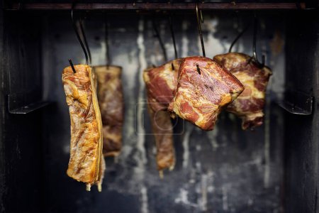 Production traditionnelle de bacon fumé, de jambon et de viande dans un fumoir domestique. Produit biologique écologique naturel. Mise en conserve en fumant