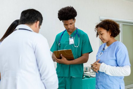 Téléchargez les photos : Professeur de médecine professionnel donner des étudiants de groupe de frais de scolarité dans la salle d'opération des patients. - en image libre de droit