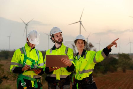 Engineer wearing safety uniform using tablet discussed plan about renewable energy at station energy power wind turbine. technology protect environment reduce global warming problems.