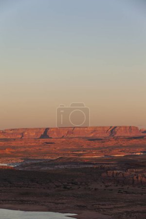 Foto de Espectacular vista de formaciones rocosas de Glen Canyon ubicadas cerca del río bajo el brillante cielo del atardecer en Colorado - Imagen libre de derechos
