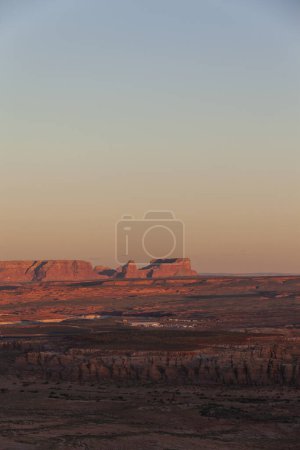 Foto de Espectacular vista de formaciones rocosas de Glen Canyon ubicadas cerca del río bajo el brillante cielo del atardecer en Colorado - Imagen libre de derechos
