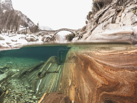 Photo for Split view of the underwater scenery in river Verzasca, canton Ticino, Switzerland at the bridge Ponte Romano, Ponte dei Salti, in the winter season - Royalty Free Image