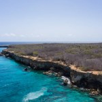Aerial view of coast of Curacao in the Caribbean Sea with turquoise water, cliff, beach and beautiful coral reef around Playa Manzalina