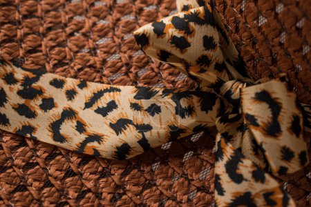 Photo for Close up of wicker hat with animal print ribbon - Royalty Free Image