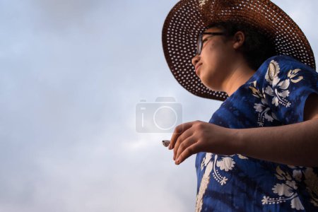 Photo for Close up of hand of woman wearing a dress and holding an earphone - Royalty Free Image