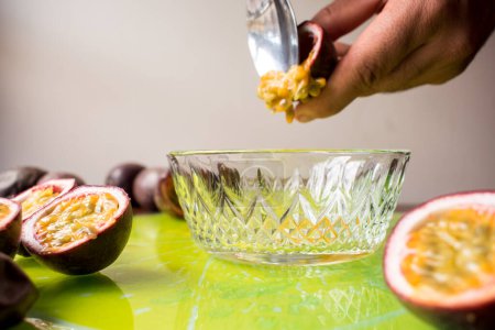 Téléchargez les photos : Mains pulvérisant un fruit tropical dans un pot en verre - en image libre de droit
