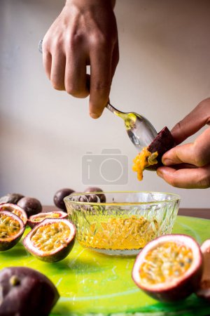 Téléchargez les photos : Mains pulvérisant un fruit tropical dans un pot en verre - en image libre de droit