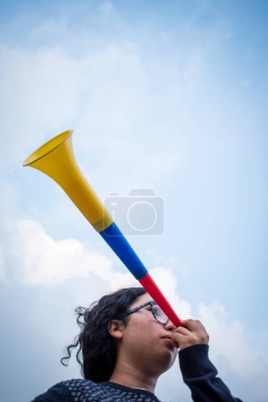 Téléchargez les photos : Femme utilisant vuvuzela pour soutenir l'équipe dans la journée nuageuse - en image libre de droit