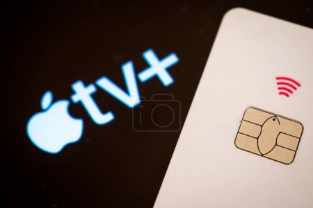 Photo for Credit card next to apple tv logo on smartphone screen - Royalty Free Image