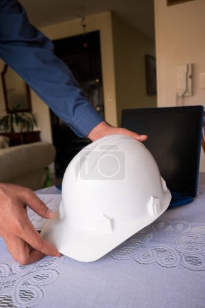 Latin construction worker man taking helmet for leaving home 