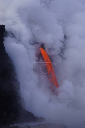 Photo for Lava flowing down from high cliff into the ocean - Royalty Free Image