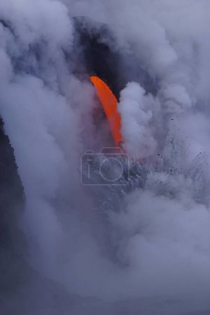 Téléchargez les photos : Lava flowing down from high cliff into the ocean - en image libre de droit