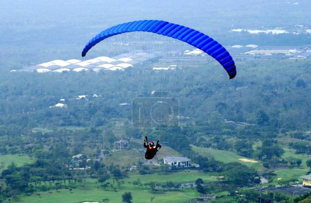 Photo for Surabaya, Indonesia - May 30, 2002: A paraglider flies over Tamandayu Luxury Housing in Pasuruan Indonesia on May 30, 2002 - Royalty Free Image