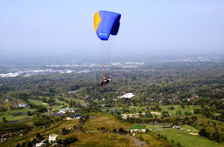 Photo for Surabaya, Indonesia - May 30, 2002: A paraglider flies over Tamandayu Luxury Housing in Pasuruan Indonesia on May 30, 2002 - Royalty Free Image