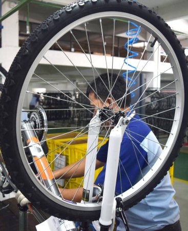 Foto de SIDOARJO, INDONESIA - 9 DE ABRIL DE 2015: Verificación de los trabajadores en la línea de montaje de la bicicleta de montaje de Indonesia Polygon en Sidoarjo, Java Oriental, Indonesia - Imagen libre de derechos